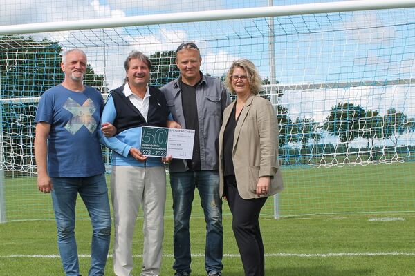 Aline Henke übergibt im Rahmen des Firmenjubiläums der hankensbütteler kunststoffverarbeitung einen Spendenscheck an den HSV Hankensbüttel für den Bau eines Beachvolleyballfeldes