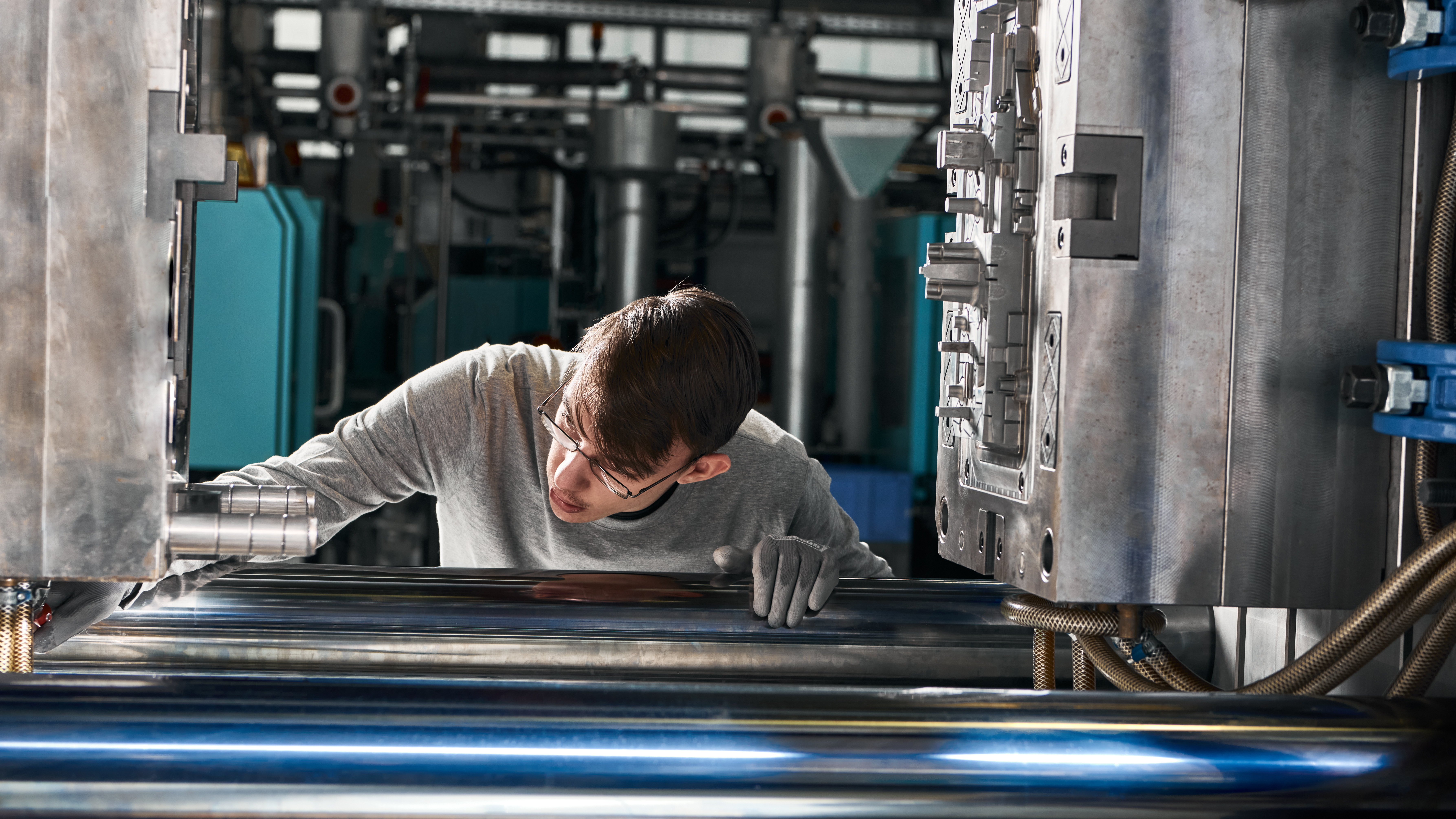 Verfahrensmechaniker prüft ein Spritzgusswerkzeug an einer geöffneten Kunststoffspritzgussmaschine
