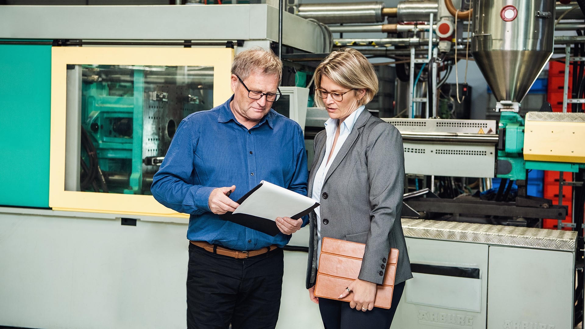 Aline Henke im Gespräch mit einem Mitarbeitenden an der Spritzgießmaschine – Entscheidungen dort treffen, wo sie entstehen: direkt im Produktionsprozess
